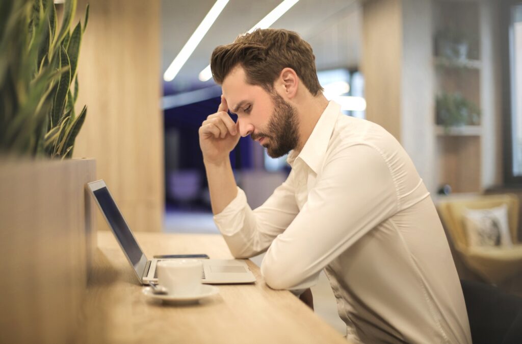 man staring at his laptop looking stressed